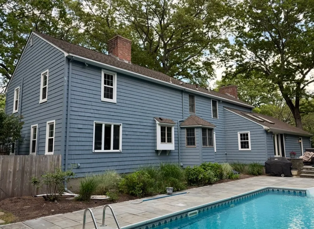 Blue shingle home exterior with fresh paint and white trim after painting
