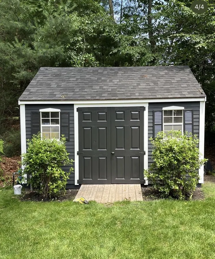 Shed exterior after painting in dark gray with black door