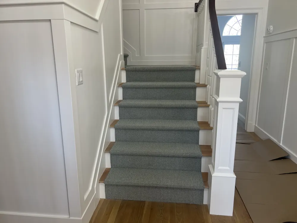 Staircase with wainscoting and white millwork finish