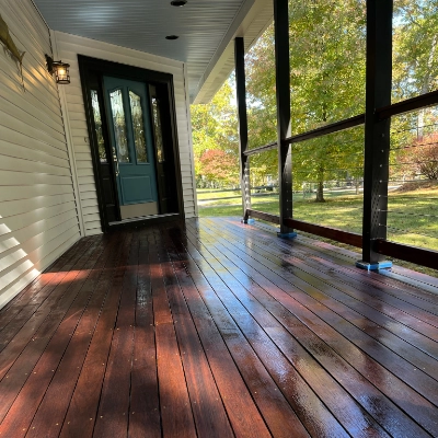 Front porch with freshly stained and glossy dark wood floorboards