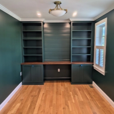 Interior room featuring dark green painted walls and matching custom built-in bookshelves