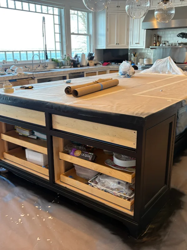 Kitchen island structure masked with protective paper during the prep phase of a full remodel